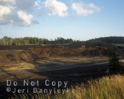 Looking west at the location of the former smelter complexes. The slag from the smelter still remains and the area is devoid of vegetation. Photo of smelter